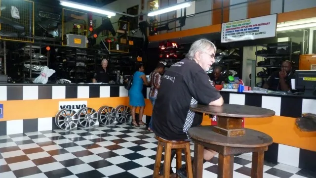 Inside the SparesBoyz showroom with alloy wheels on a checkerboard floor